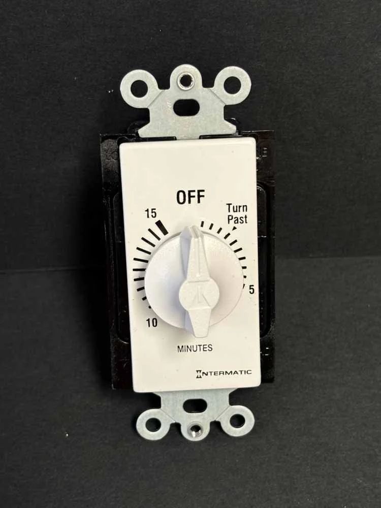 White timer switch on black wall plate, set around 12 minutes, with “OFF” and “Turn Fast” labels.