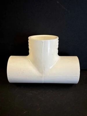 White PVC T-fitting on a black background