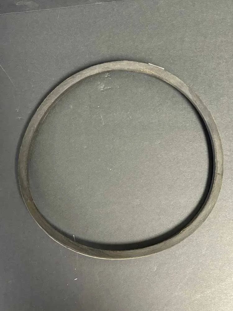 Close-up of a round black rubber gasket on a gray surface