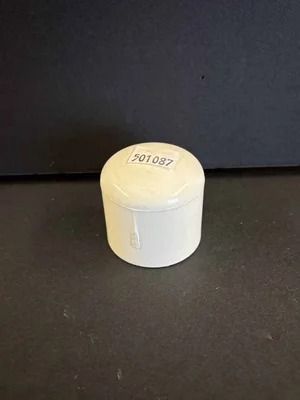 Small white cylindrical container with a lid, labeled 501087, on a dark surface.