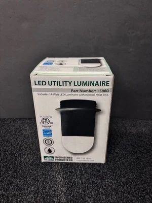 LED utility luminaire product box on a dark surface, showing a black-and-white wall light fixture.