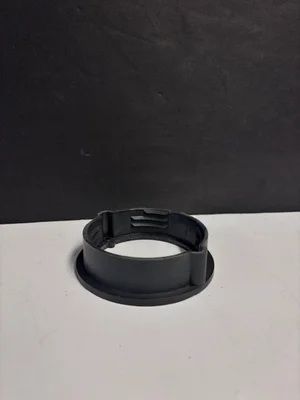 Black plastic wristband or ring-shaped strap on a white surface against a dark background