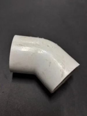 White PVC elbow pipe fitting on a dark background