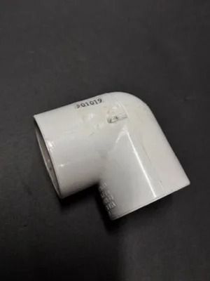 White PVC elbow pipe fitting on a dark background