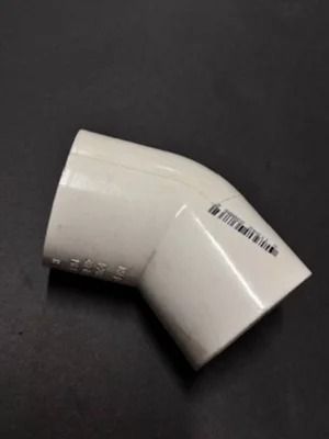 White PVC elbow pipe fitting on a dark background