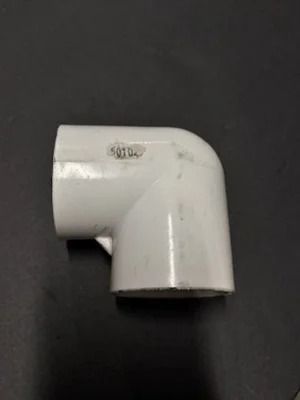 White PVC elbow pipe fitting on a dark background