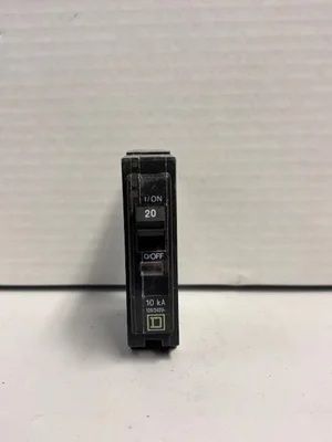 Close-up of a black electrical breaker switch with white markings on a light background