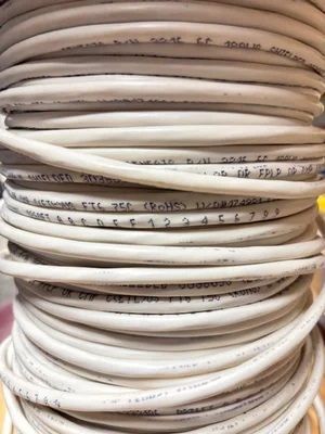 Stacked coiled white cables with handwritten labels on each loop