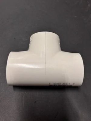 White PVC T-fitting connector on a dark background