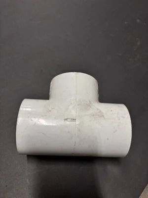 White PVC T-fitting on a dark background