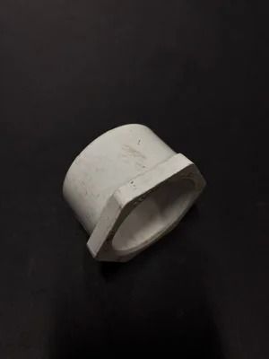 White plastic pipe connector on a black background