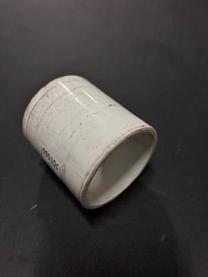 White ceramic cup lying on its side on a dark surface