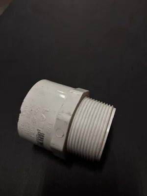 White PVC pipe fitting with threaded end on a dark background