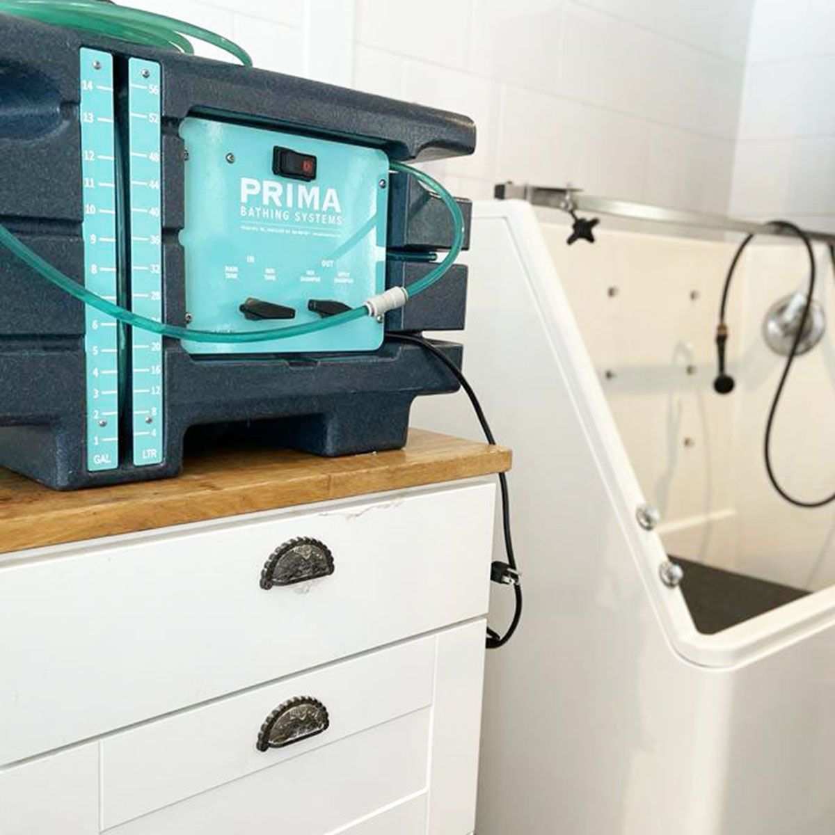 Turquoise medical device on a white cabinet beside a bathroom sink and bathtub