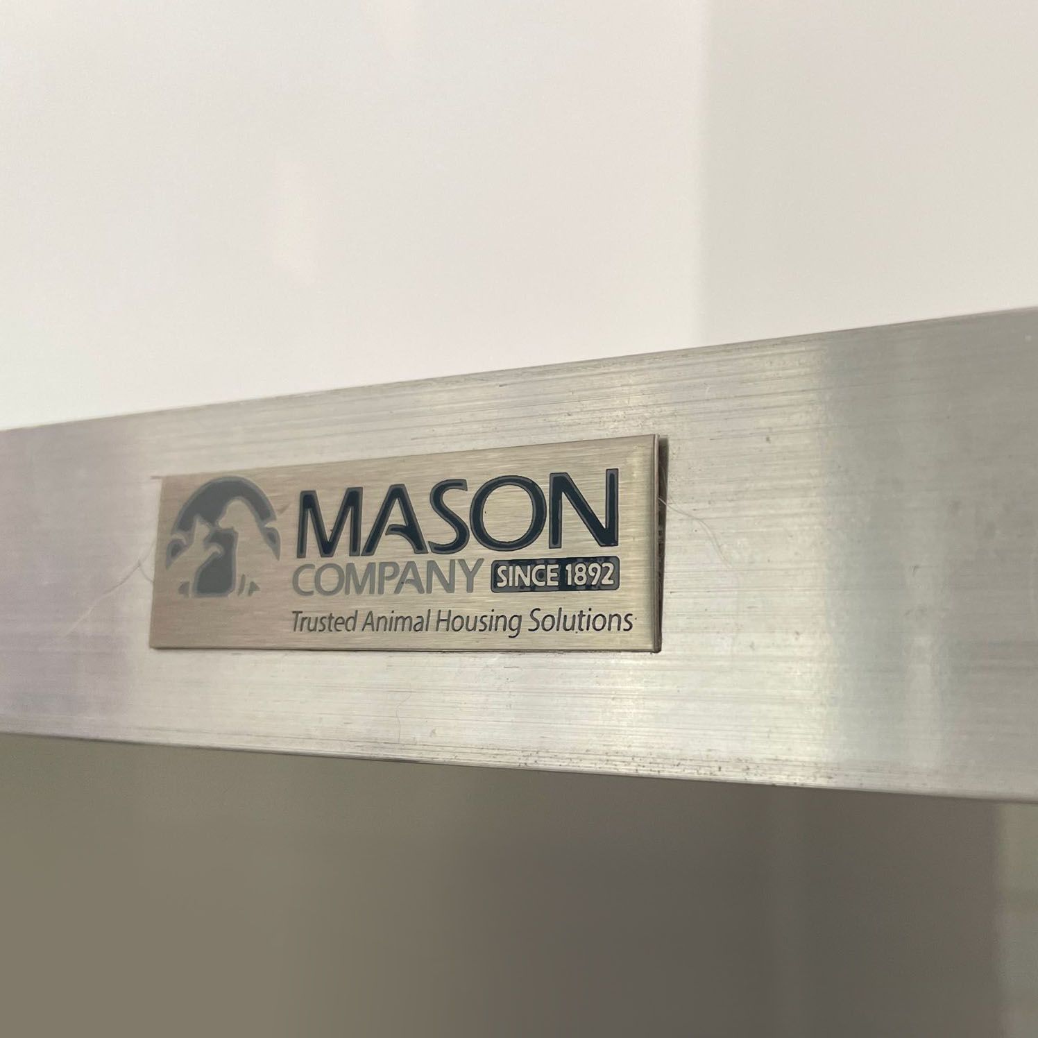 Mason Company logo plaque on a brushed metal surface