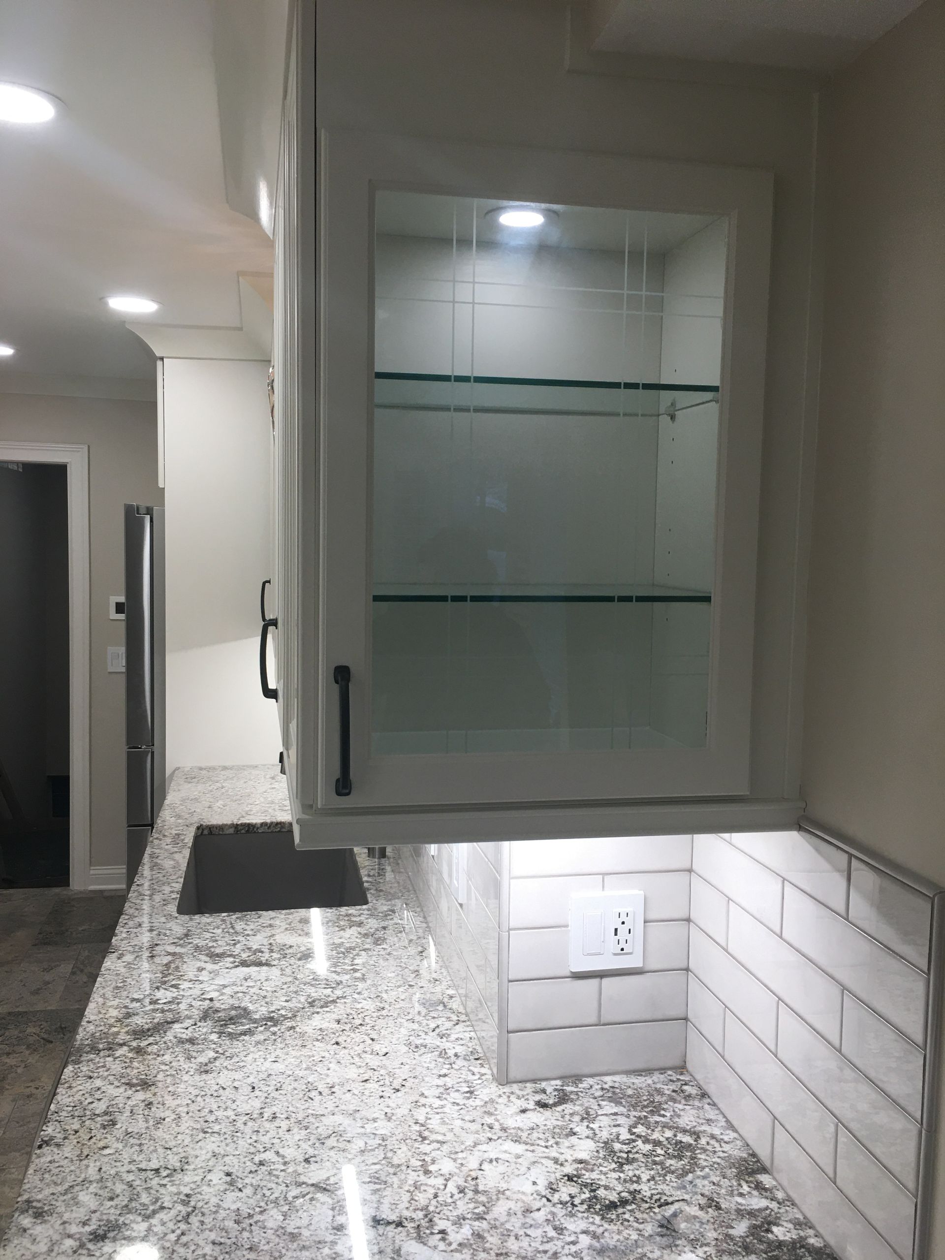 Modern kitchen with gray cabinets, granite countertop, and white subway tile backsplash