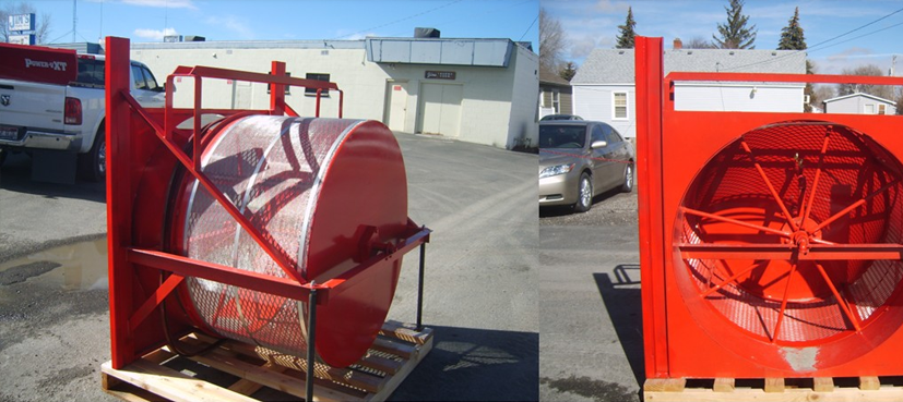 Red metal industrial drum structure sitting on a wooden pallet outdoors.