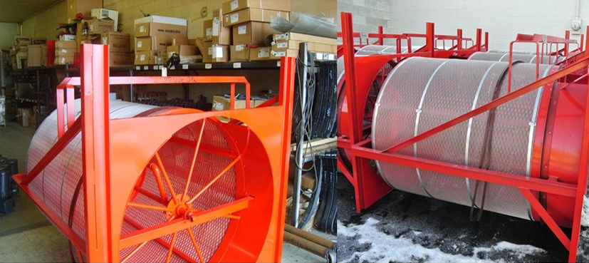 Two red industrial sieves with mesh cylinders in a warehouse setting.