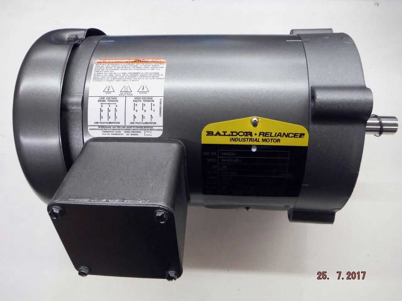 A gray Baldor industrial motor with a label showing wiring diagrams, mounted on a surface.