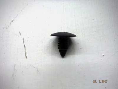 Black plastic push-in fastener with a rounded head and ribbed shaft, resting on a white surface.