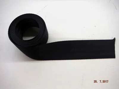 A roll of black fabric ribbon unwinding on a white surface.