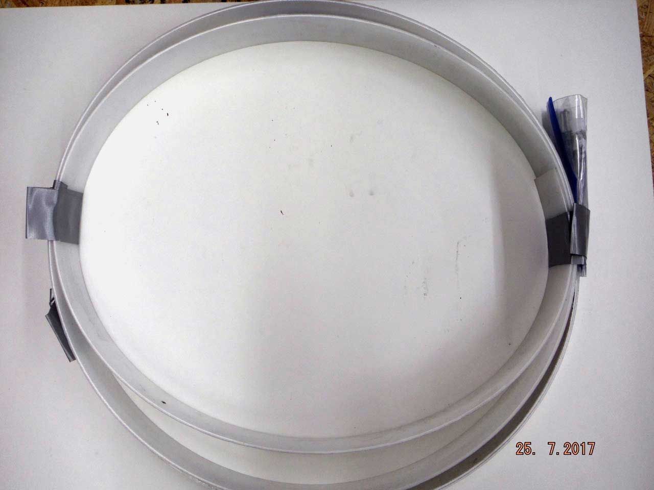 Overhead view of three nested metal rings with taped closures, resting on a white surface.