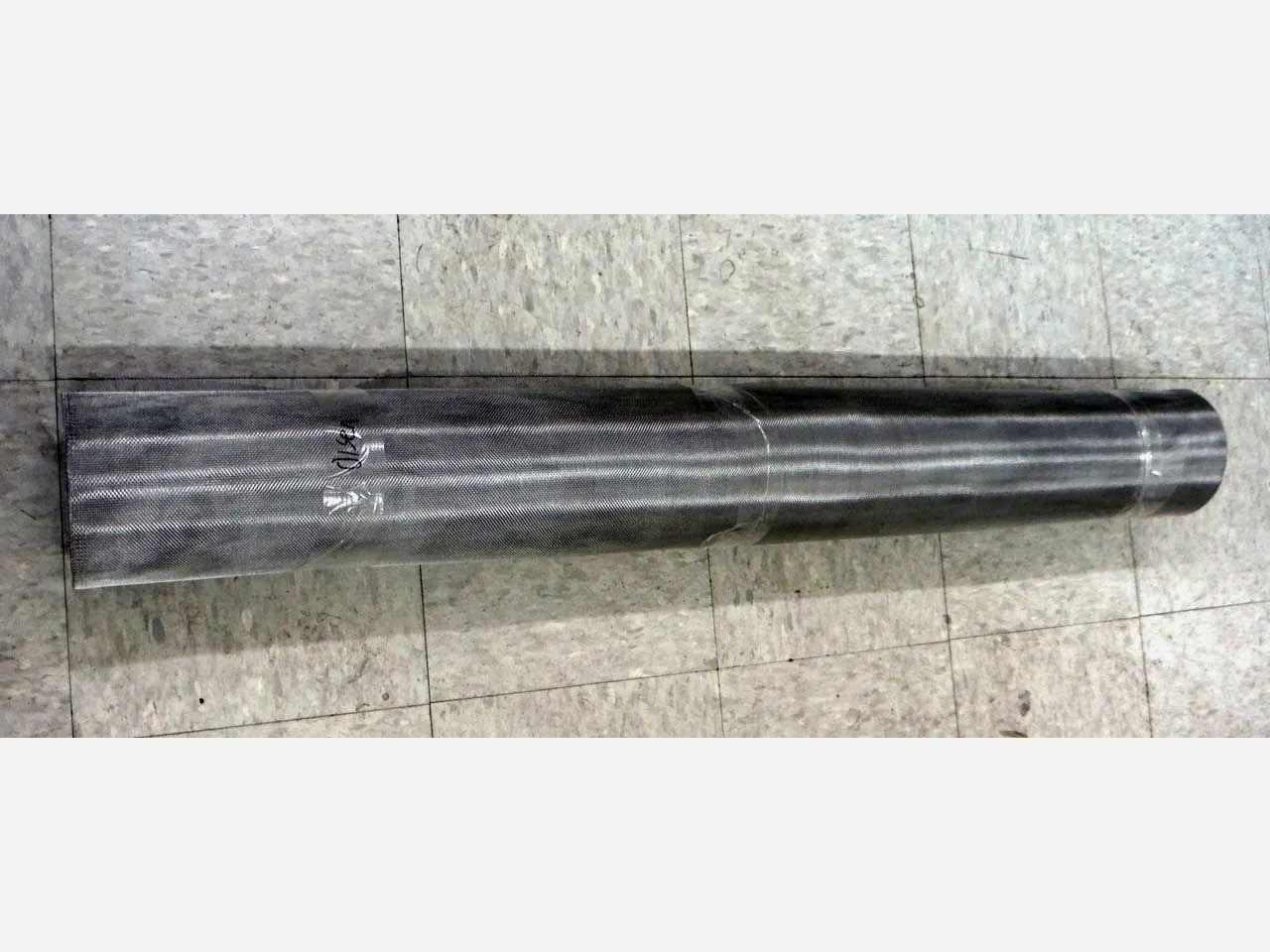 A long, cylindrical, metallic component with a wider, flattened end and a narrower cylindrical end, lying on a tiled surface.