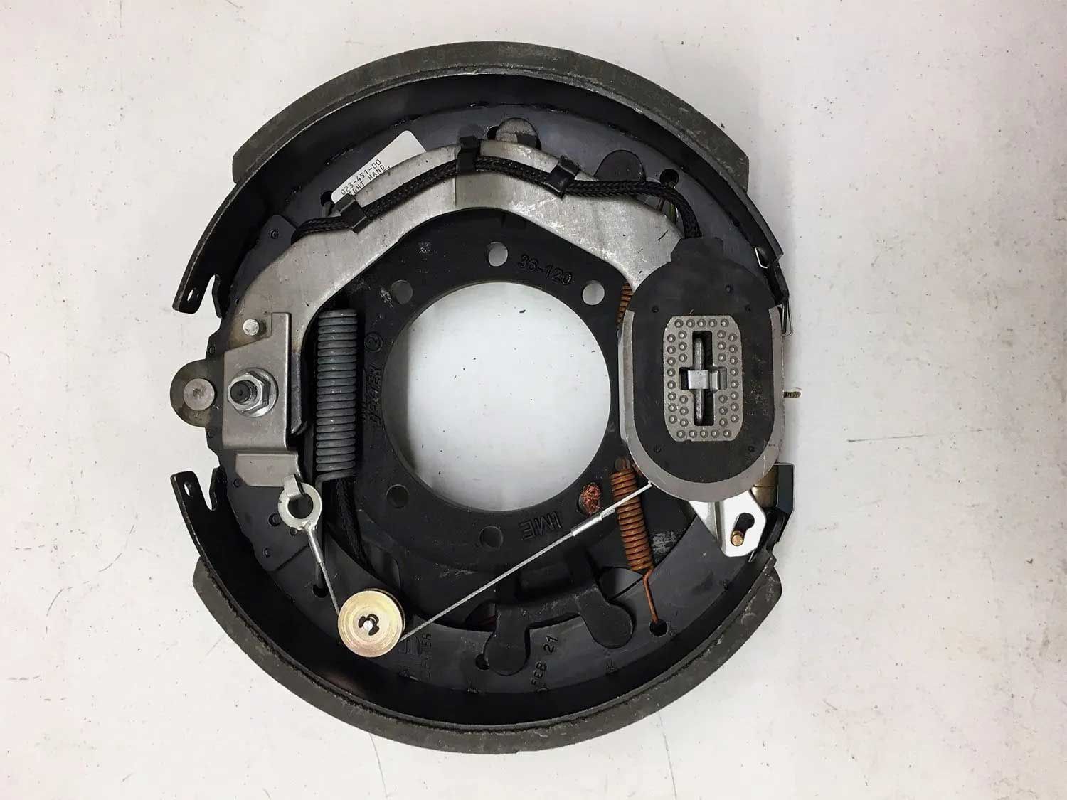 Trailer drum brake assembly with brake shoes, springs, and backing plate.