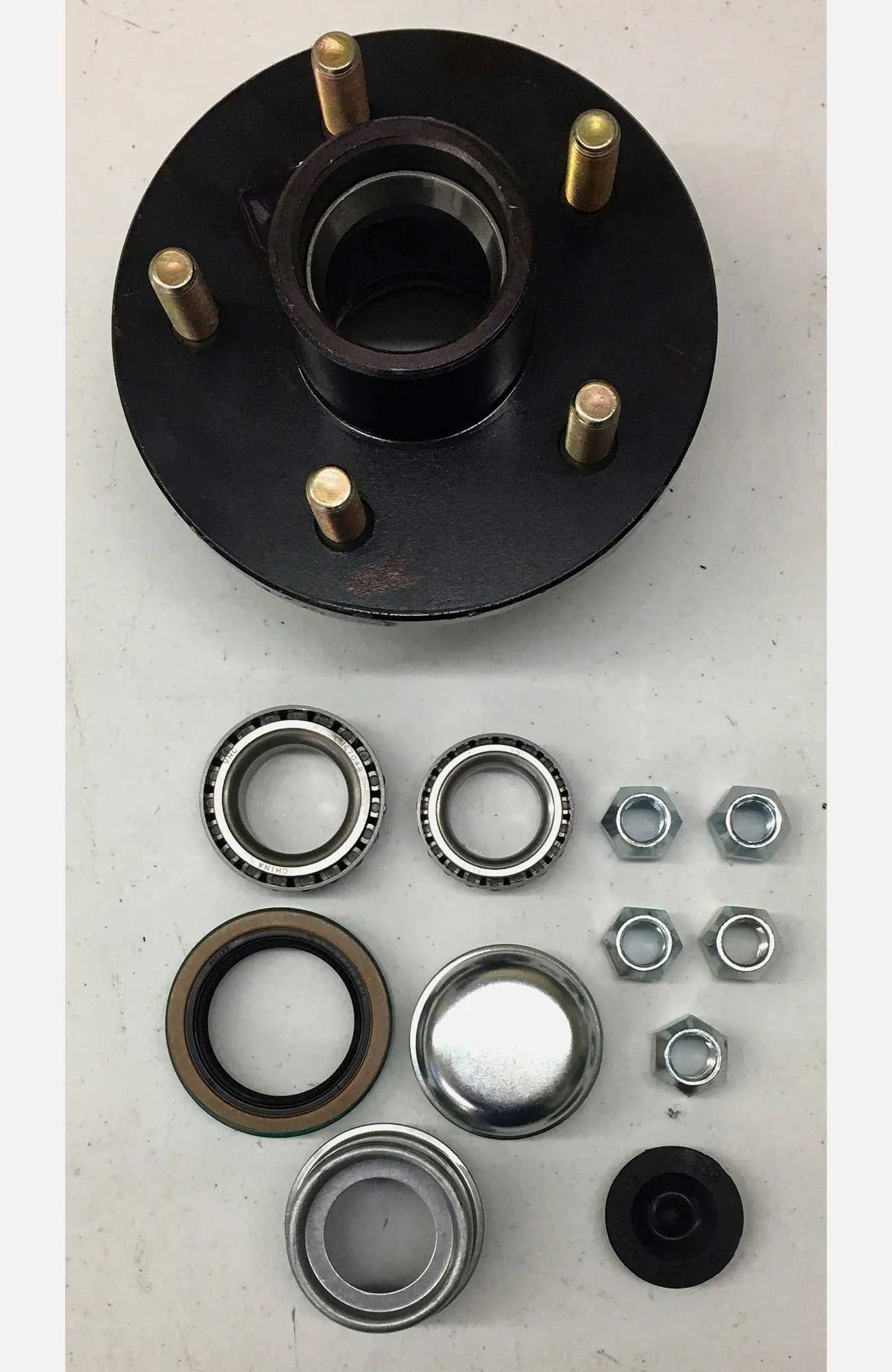 Trailer hub assembly with bearings, nuts, and seals arranged for maintenance. Black hub, silver metal, and rubber parts.