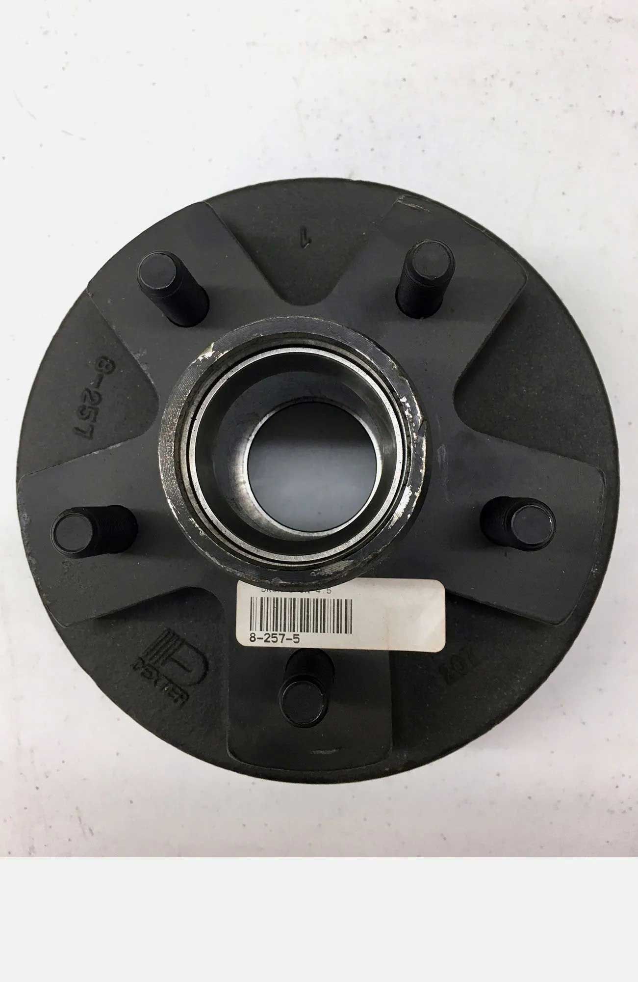 Black trailer hub with six lug nuts and a central bearing race. A white label with a barcode is attached.