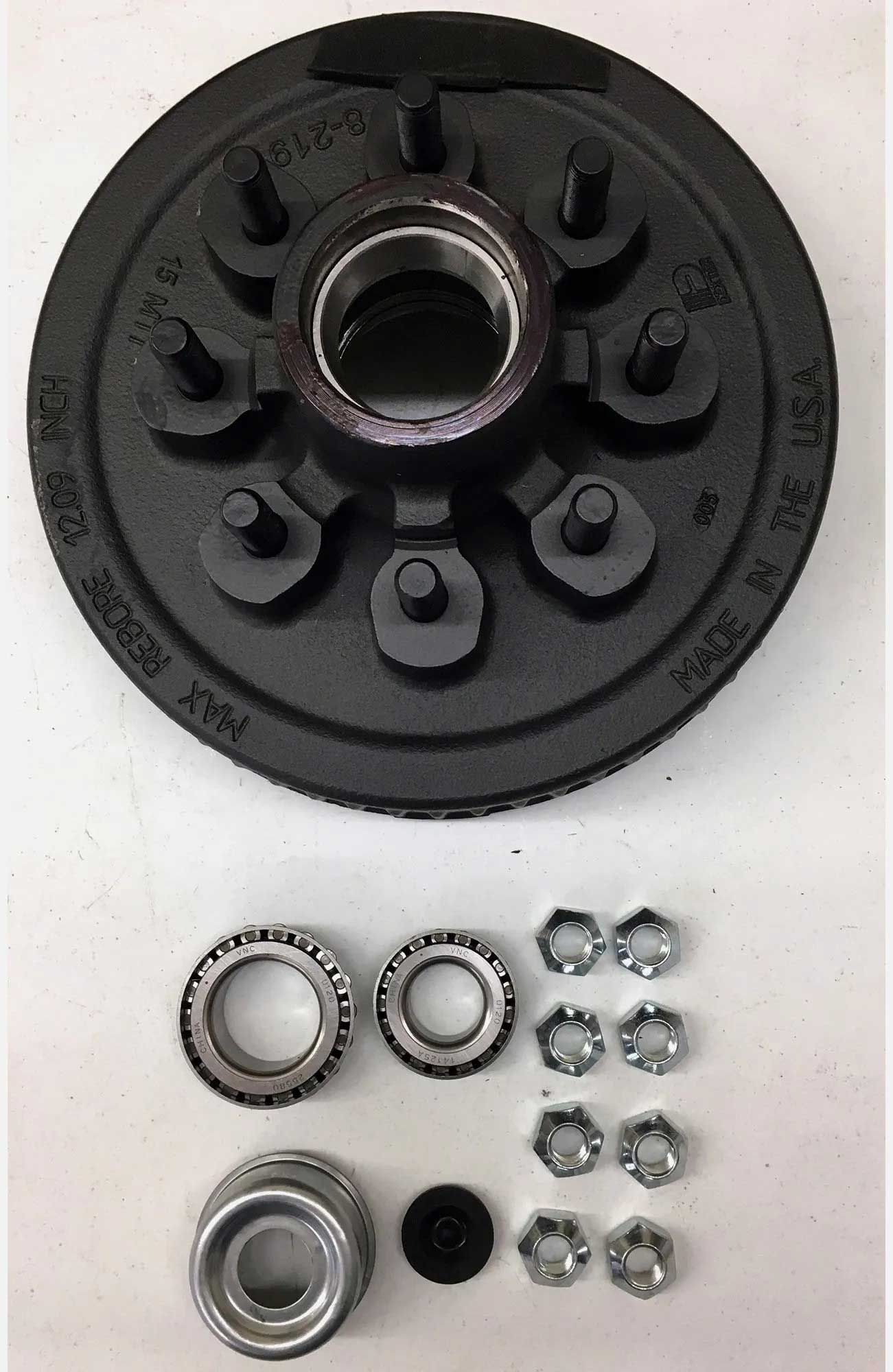 Black trailer hub assembly with bearings, nuts, and related hardware on a white surface.