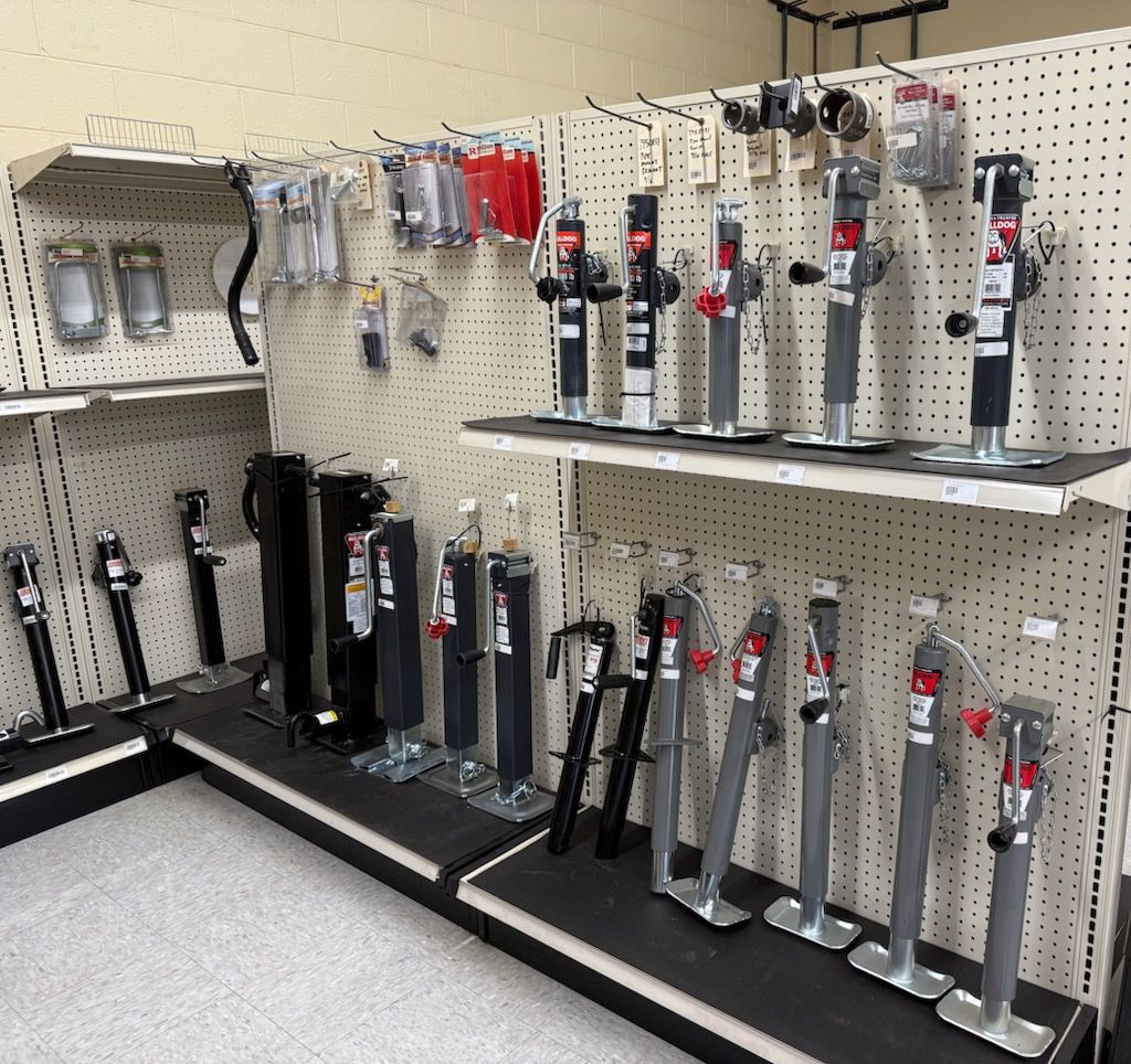 Shelves displaying various trailer jacks and accessories in a store.