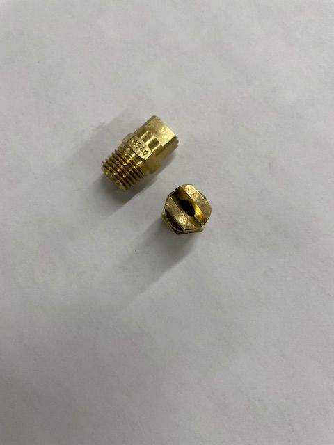 Two brass carburetor jets on a white surface. One is threaded, the other is a nozzle.