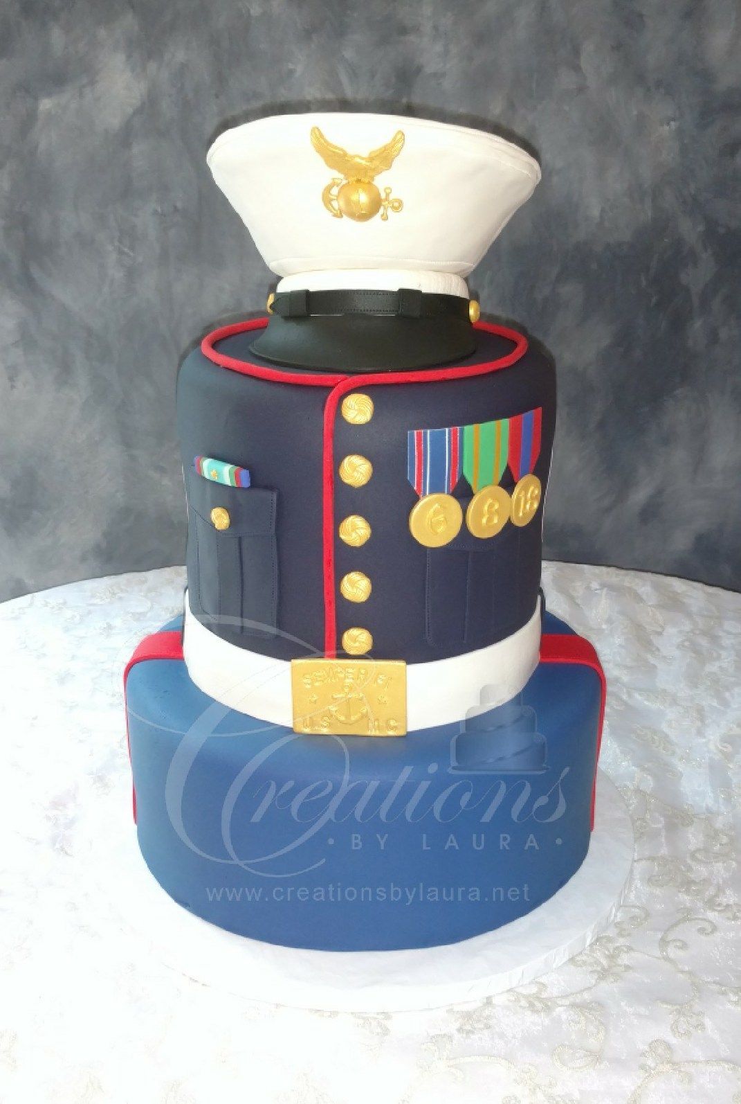 Marine dress uniform cake with white hat, gold buttons, medals, and red trim on a blue base