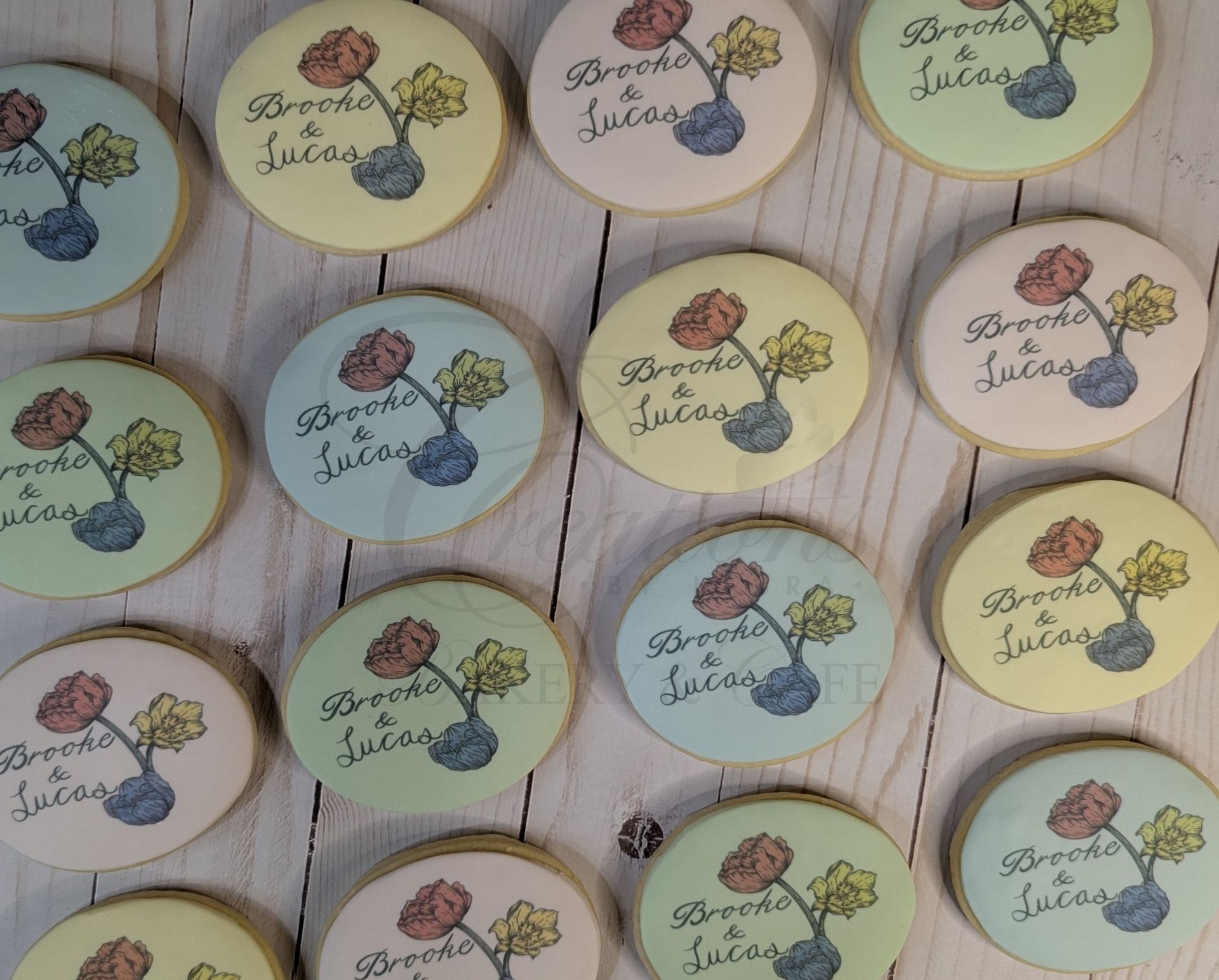 Assorted pastel round floral tags with cursive text arranged on a light wooden surface