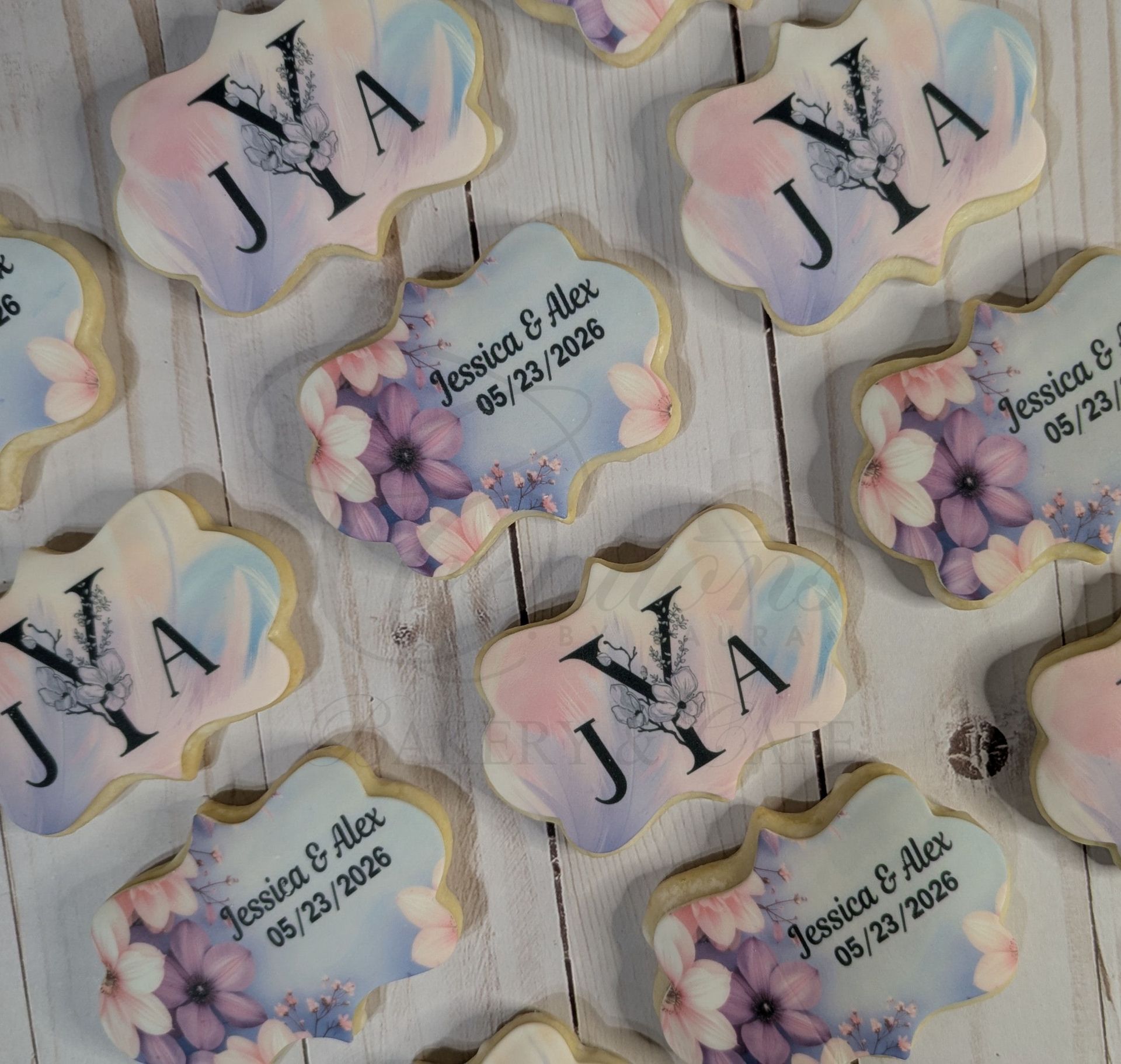 Assorted pastel cloud-shaped name tags with floral accents and black initials on a patterned background