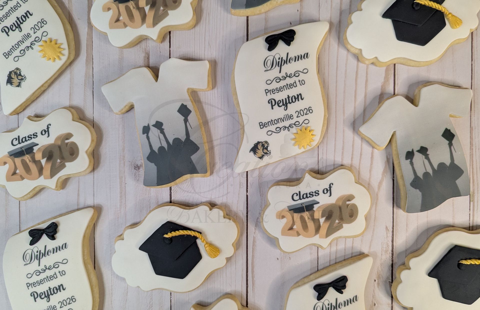 Graduation-themed cookies with caps, 2025, and silhouettes in gold and black on a white table