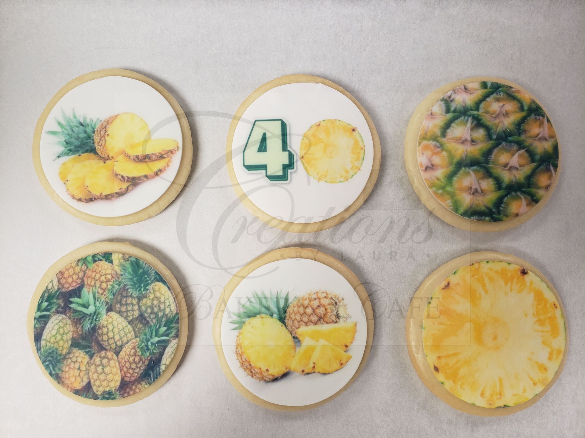 Six round pineapple-themed cookies arranged in two rows on a light background.