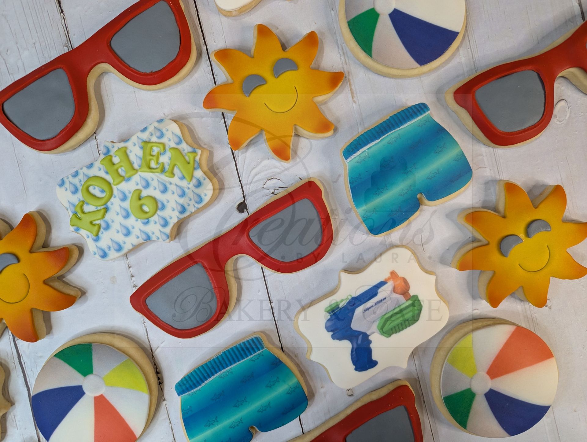Red sunglasses, yellow flowers, beach balls, and colorful bottle cookies on a light background