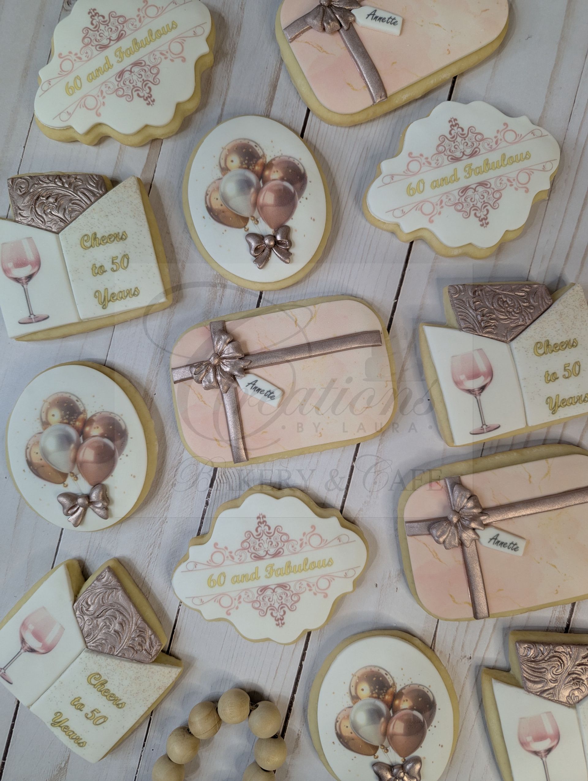 Pastel cookies arranged on a table, with vintage floral and balloon designs and twine bows.