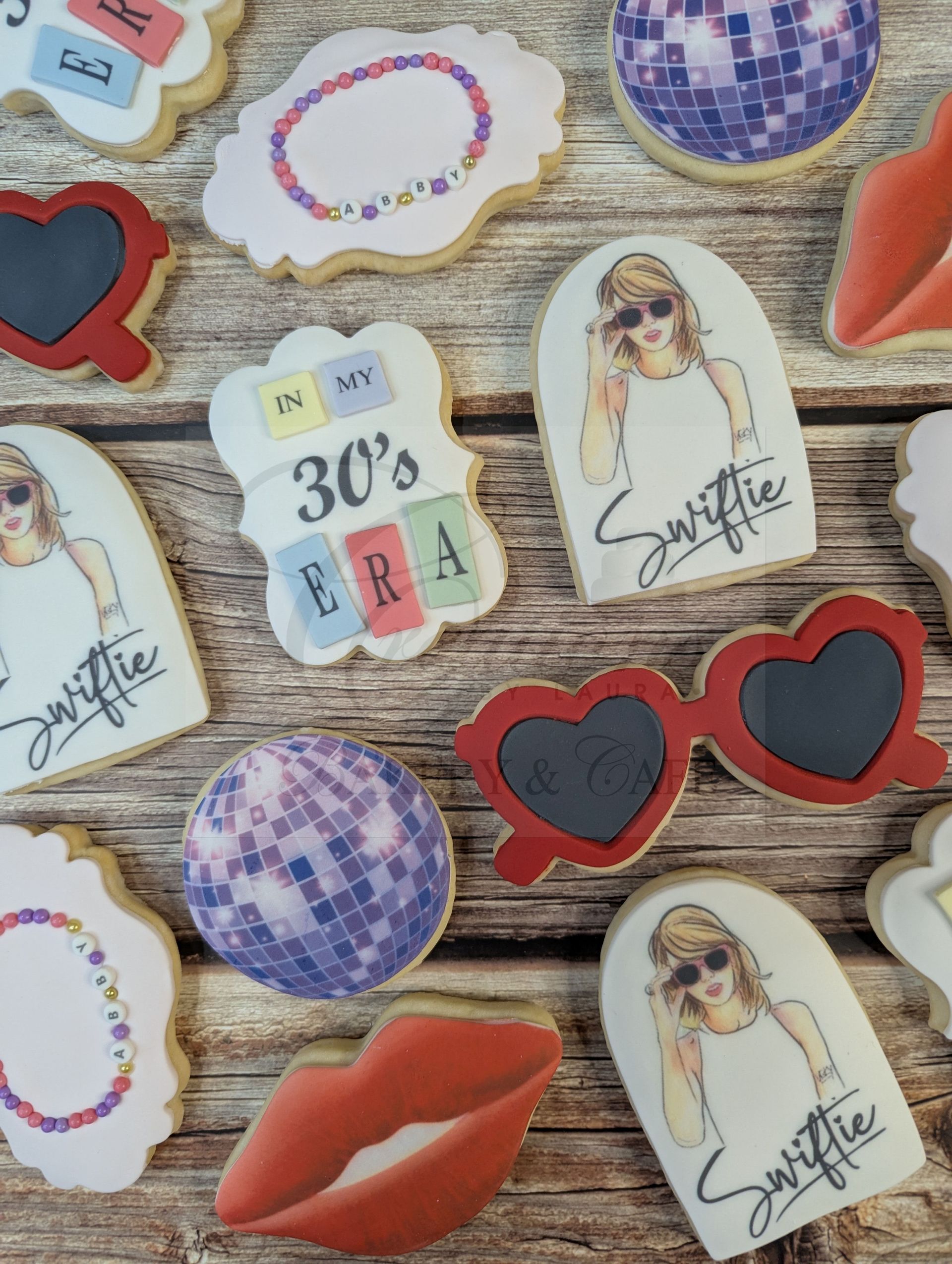 Assorted colorful cookies on a textured surface, including hearts, lips, sunglasses, and a “30’s” label