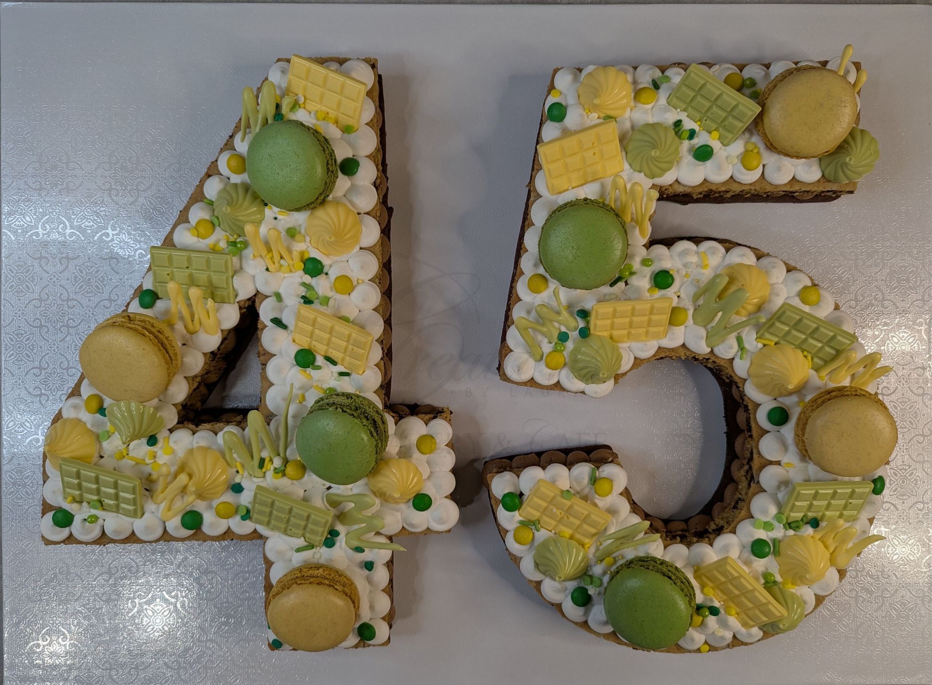 Decorated number 45 made of flowers and green-yellow candies on a light gray surface