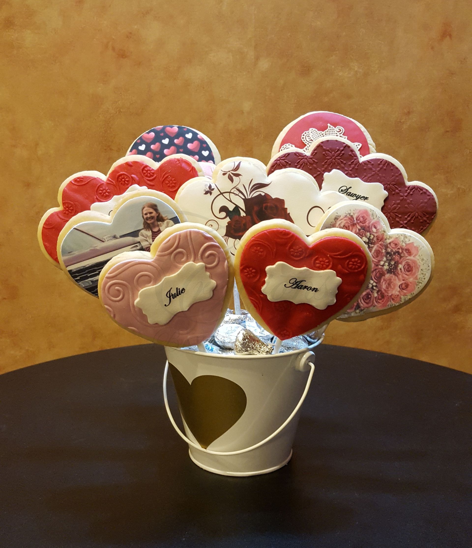 Heart-shaped decorated cookies in a white bucket on a table