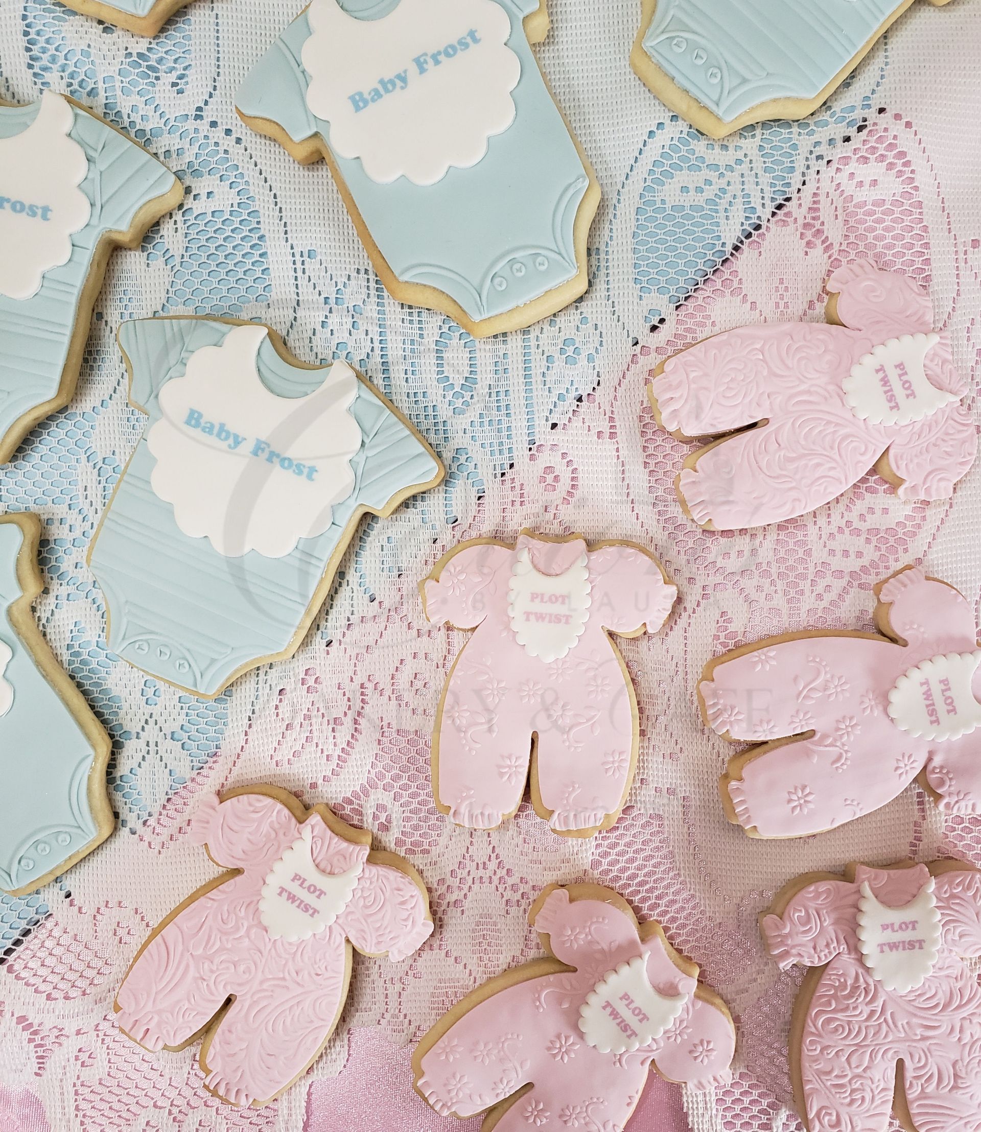 Pastel teddy bear-shaped cookies with lace ribbons and scalloped tags on a decorated tablecloth