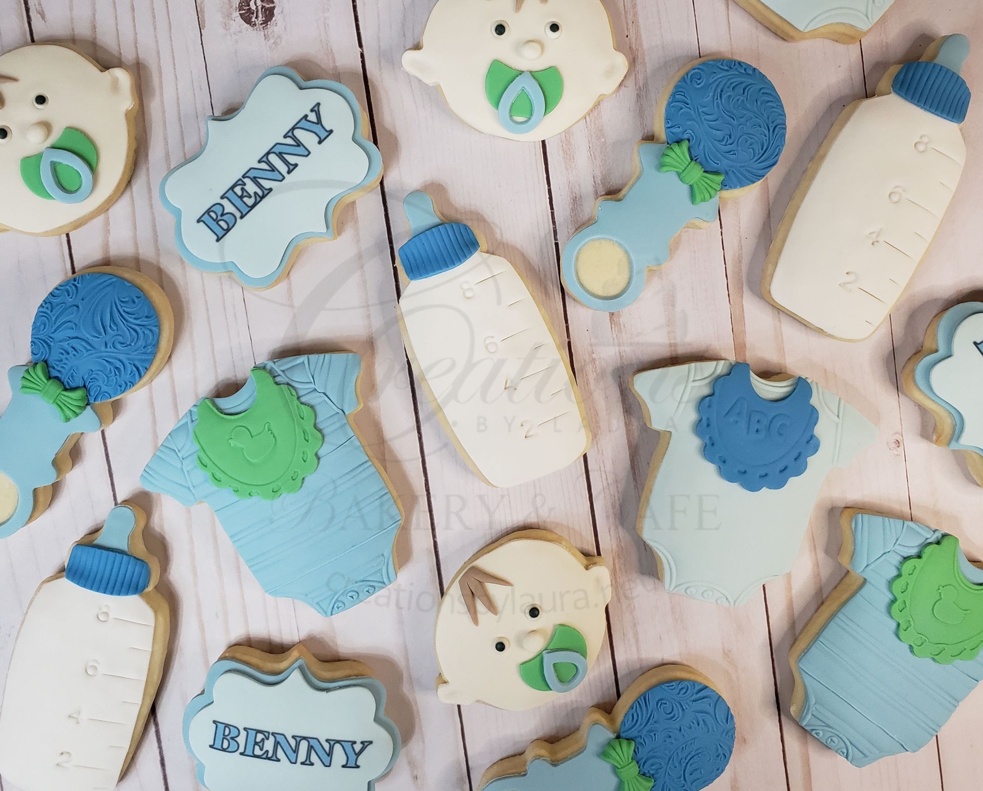Blue and green bunny-shaped cookies and treats with Bunny tags on a pastel wooden background