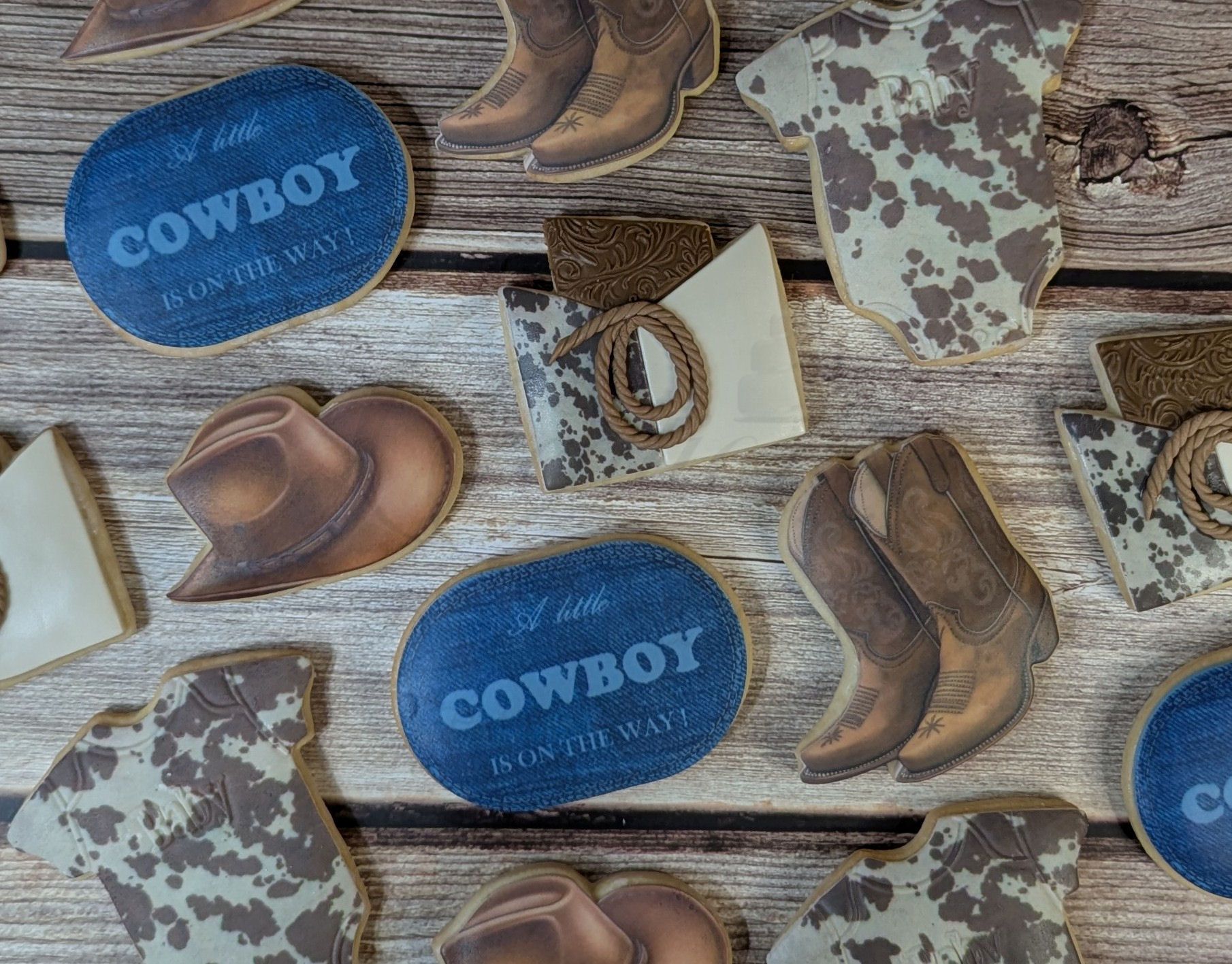 Cowboy-themed pattern with boots, hats, horseshoes, and blue COWBOY labels on wood planks