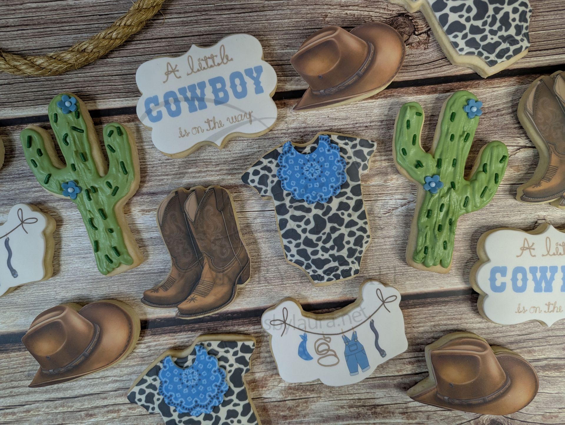Western cowboy-themed scrapbook decor with boots, cacti, hats, and blue accents on a wood background