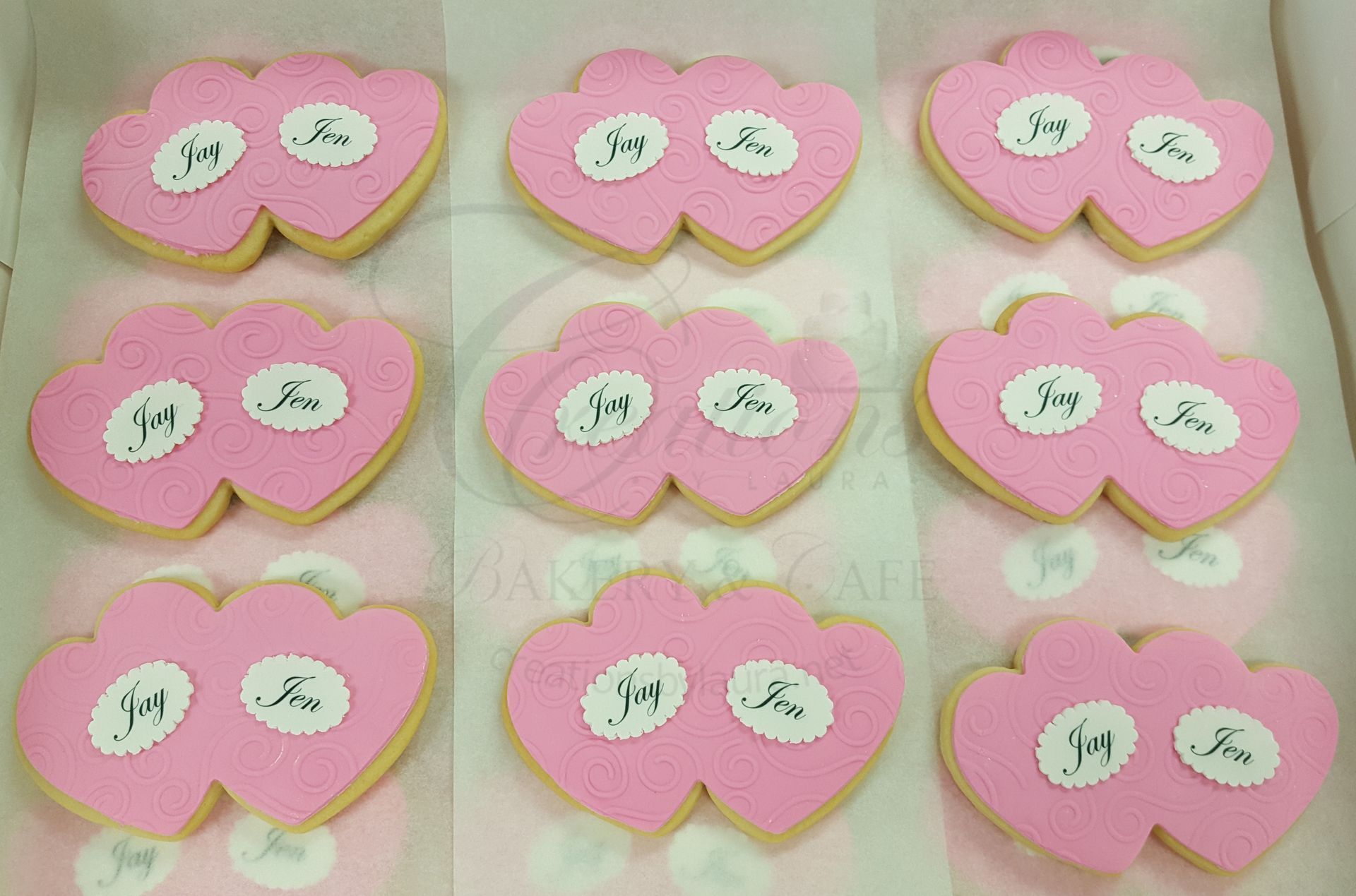 Nine pink heart-shaped crafts with white oval labels arranged in a 3x3 grid.