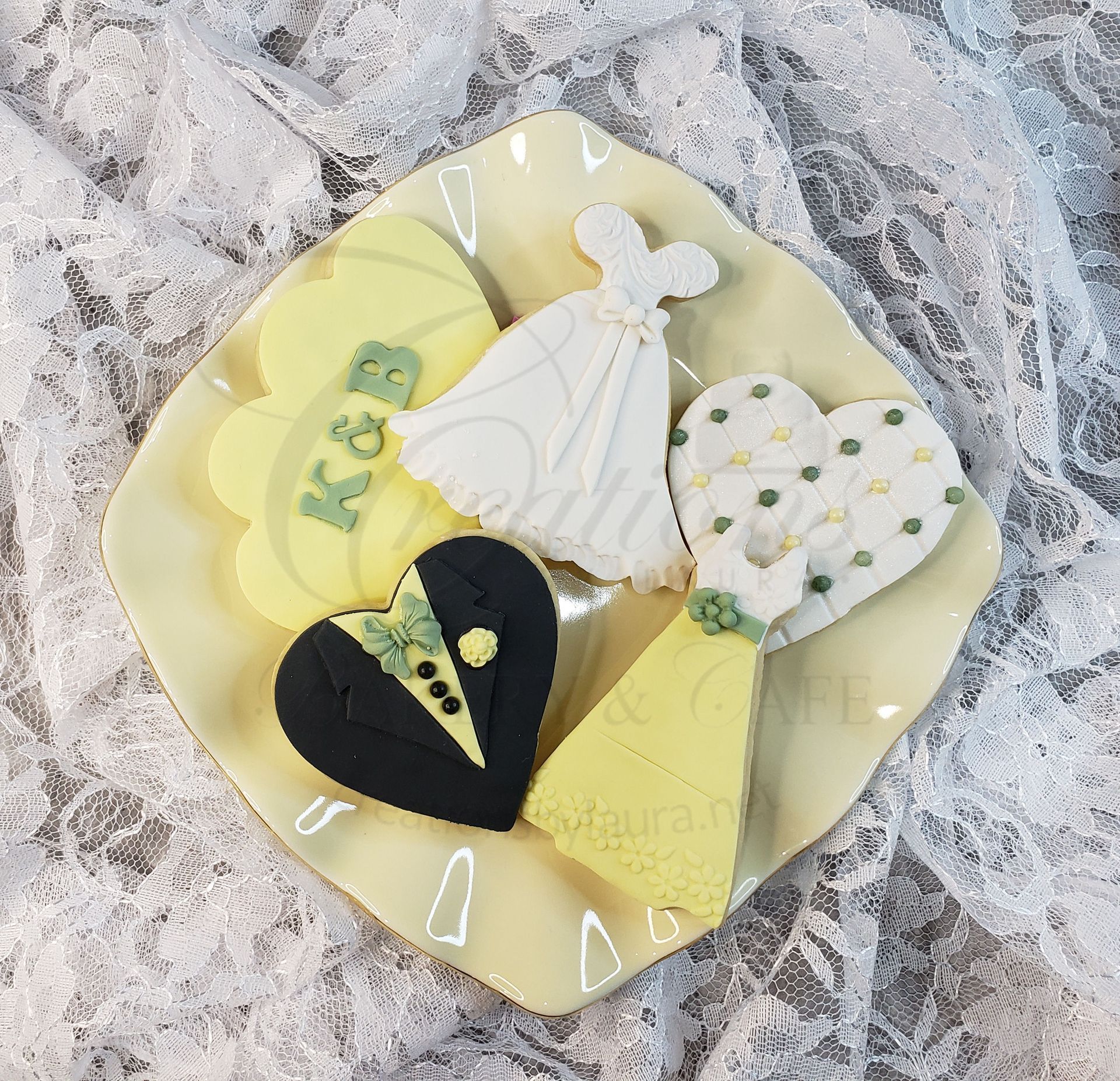 Decorated pastel cake with wedding dress, hearts, and K&B topper on lace background