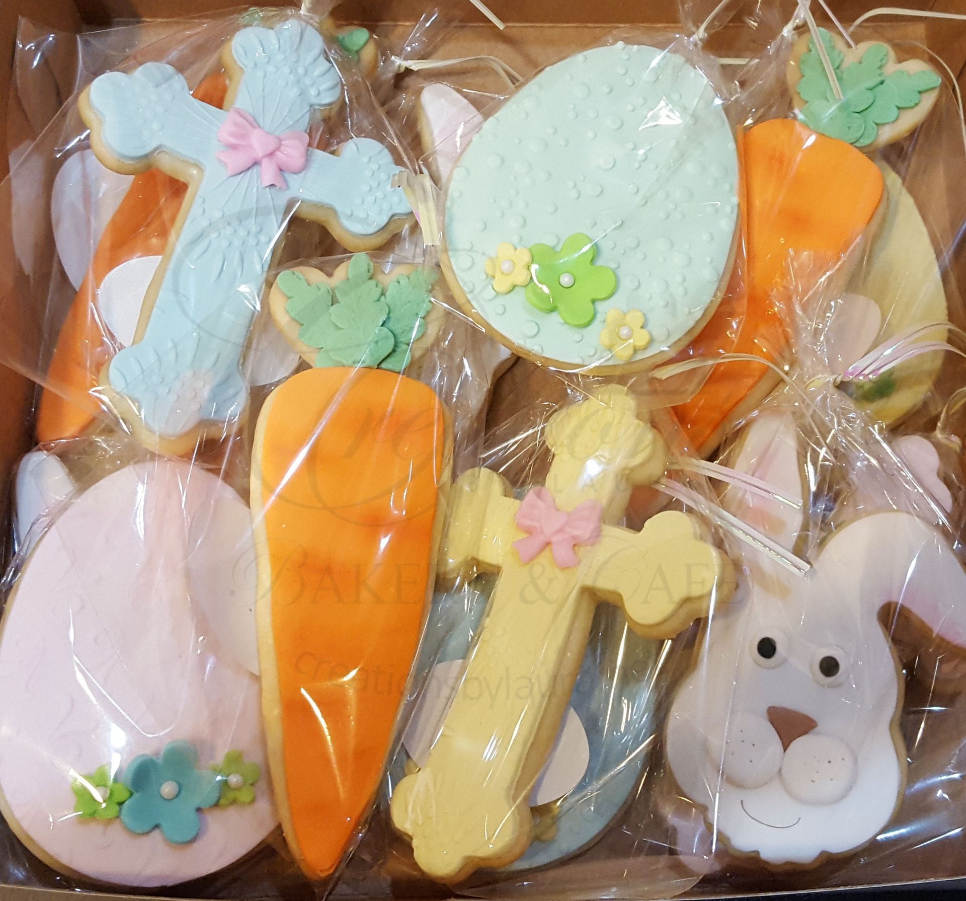 Assorted pastel bunny-shaped decorated cookies wrapped in clear plastic.